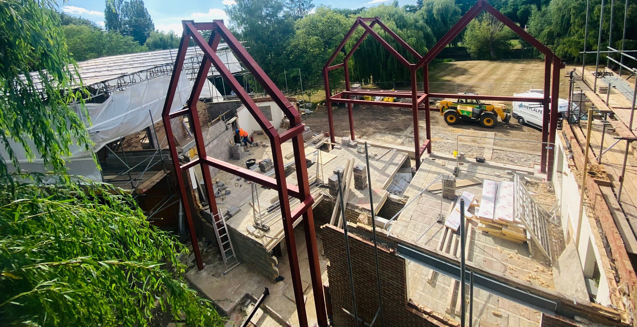 A building under construction with a red steel frame fabricated by Metcalfe