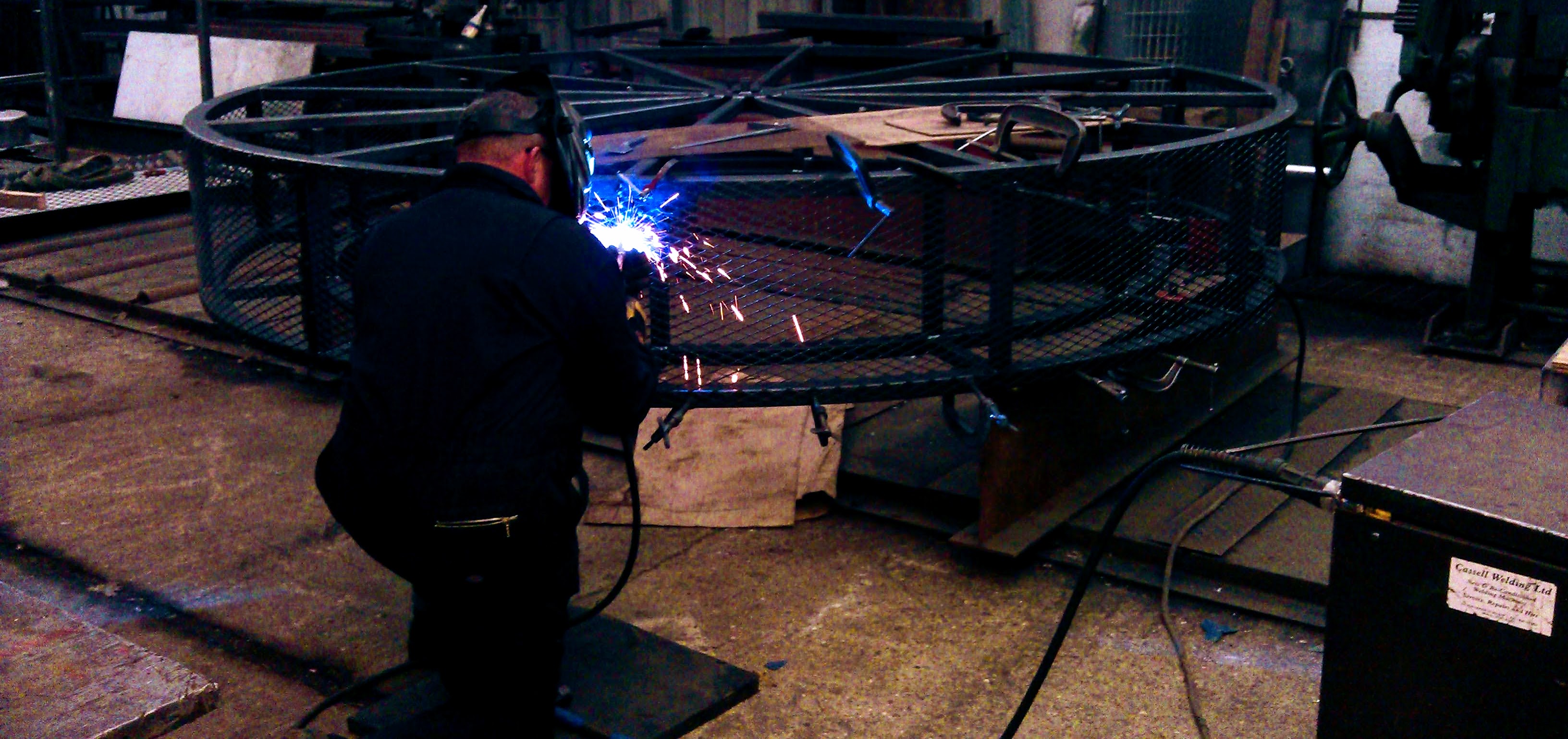 man welding repairs to a large steel structure