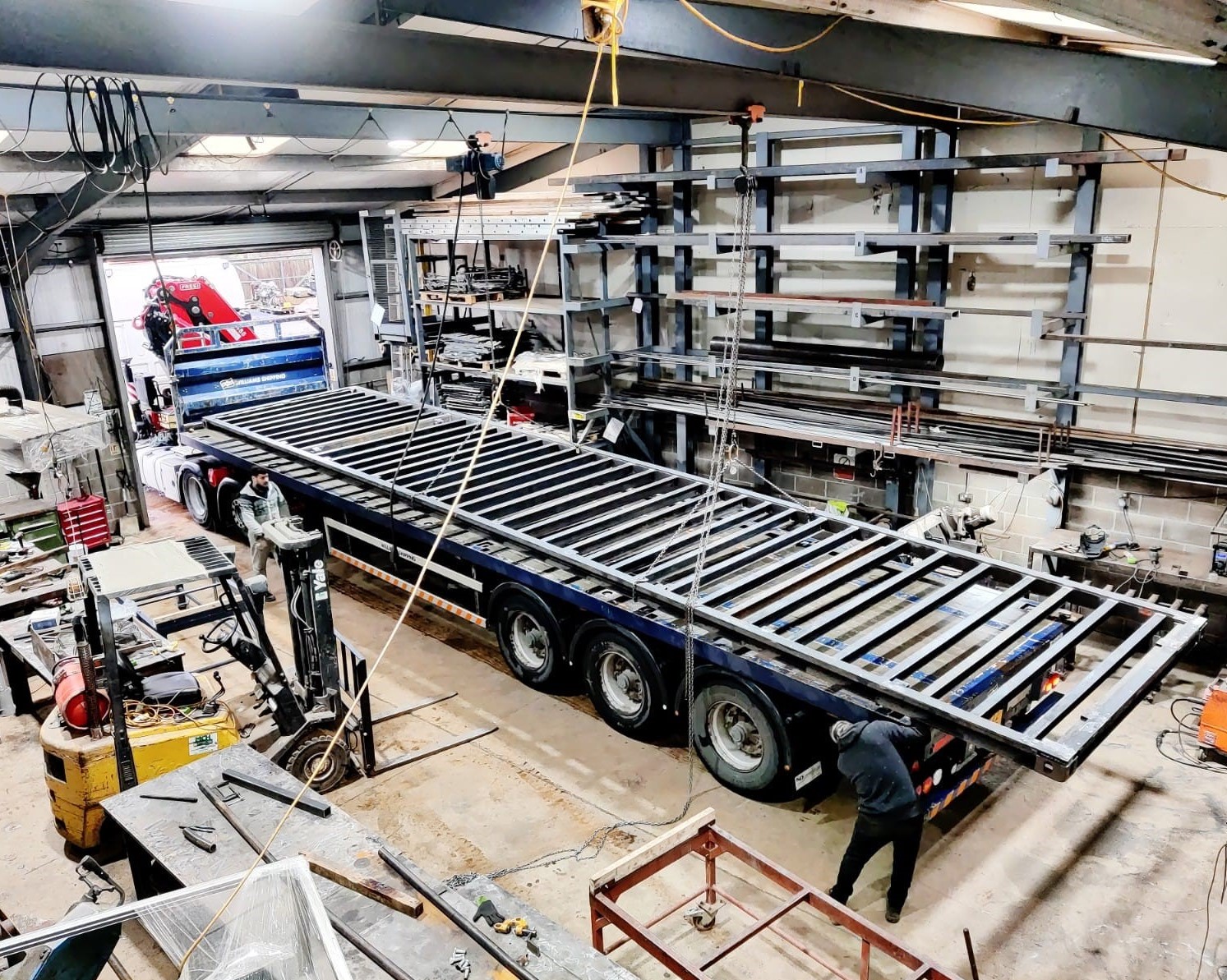 A large metal Skid Frame loaded on a lorry in a busy metal fabrication workshop